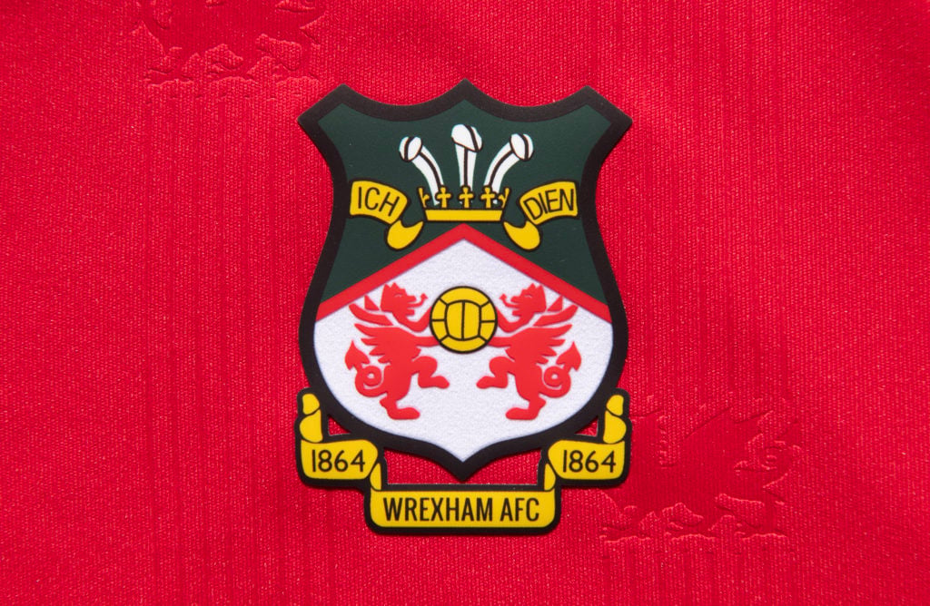 The official club badge of Wrexham AFC on a home shirt