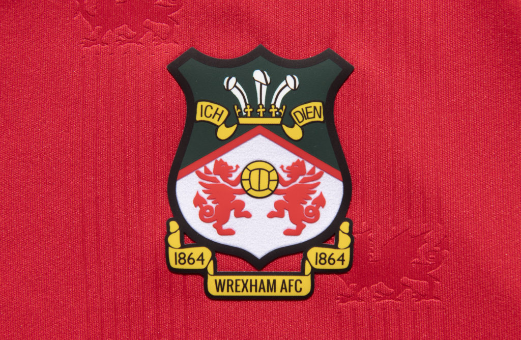 The official club badge of Wrexham AFC on a home shirt