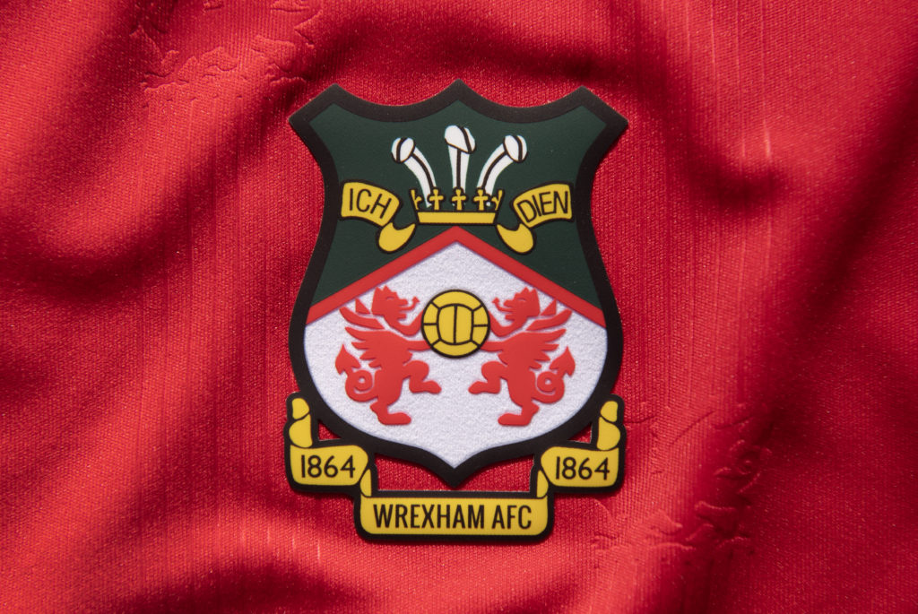 The official club badge of Wrexham AFC on a home shirt