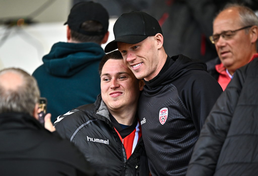 Wrexham player James McClean takes a picture with a Derry City fan.