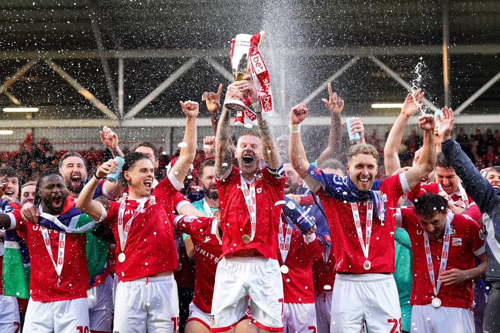 Wrexham players celebrate winning promotion to the Championship after beating Charlton Athletic.