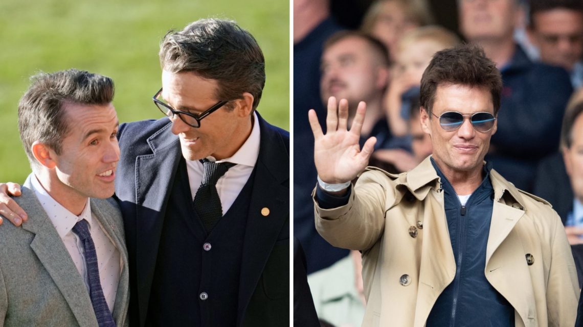 Rob McElhenney and Ryan Reynolds talk as they wait for the arrival of King Charles III and Camilla, Queen Consort, for their visit to Wrexham AFC. ...