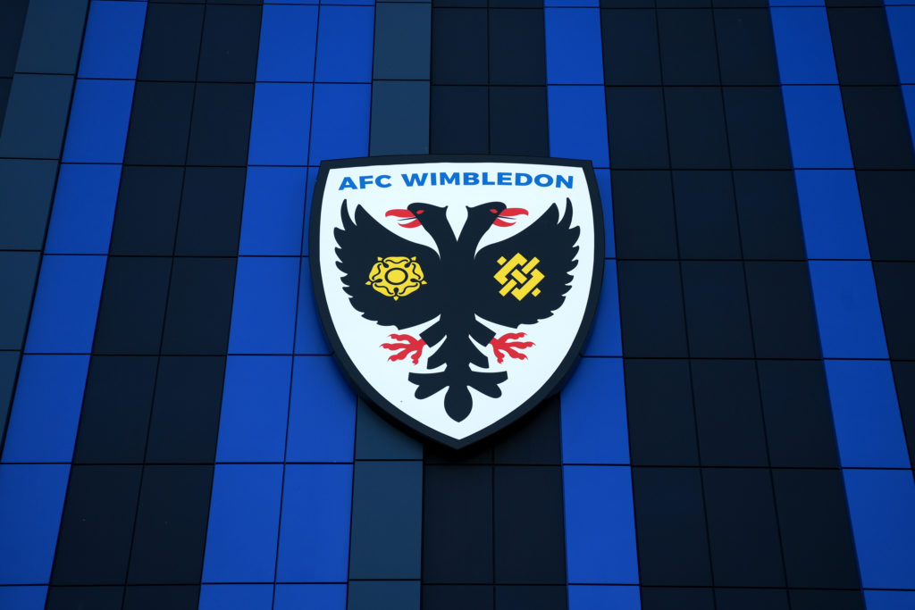 A detailed view of the AFC Wimbledon badge is seen outside the stadium.