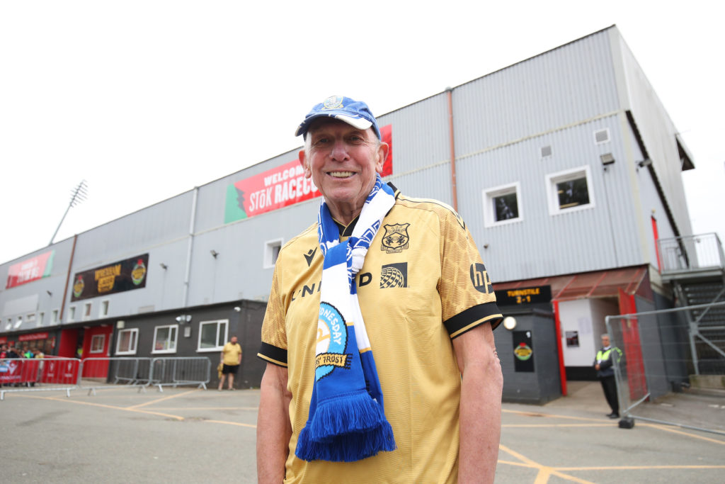Wrexham fan pose for a photo outside the stadium