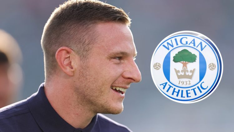 Paul Mullin prior to Chelsea FC v Wrexham - Pre-Season Friendly. The club crest of Wigan Athletic is seen outside DW Stadium prior to the Sky Bet L...
