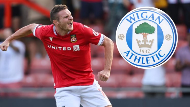 Paul Mullin of Wrexham celebrates victory during the Sky Bet League Two match between Wrexham and Doncaster Rovers. The club crest of Wigan Athleti...