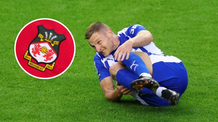 Paul Mullin during Wigan Athletic v Stockport County - Carabao Cup Second Round. Wrexham badge on a red home shirt.