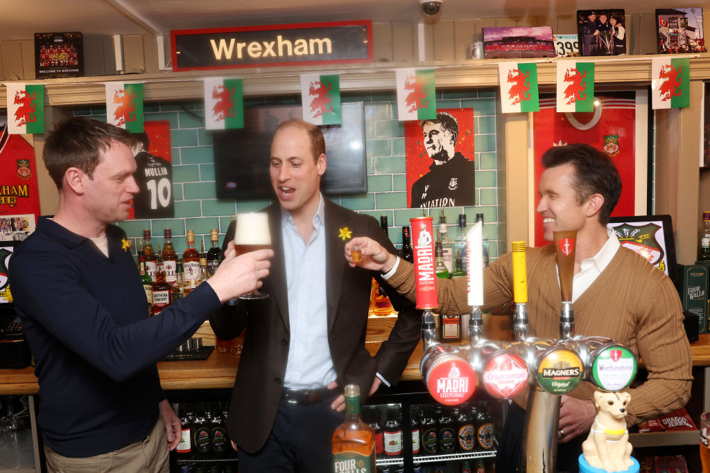 Prince William, Prince of Wales (C) and Chairman of Wrexham AFC Rob McElhenney (R) share a drink at The Turf Pub