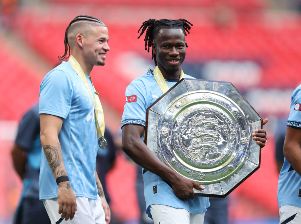 Kalvin Phillips and Issa Kabore of Manchester City celebrate with the trophy