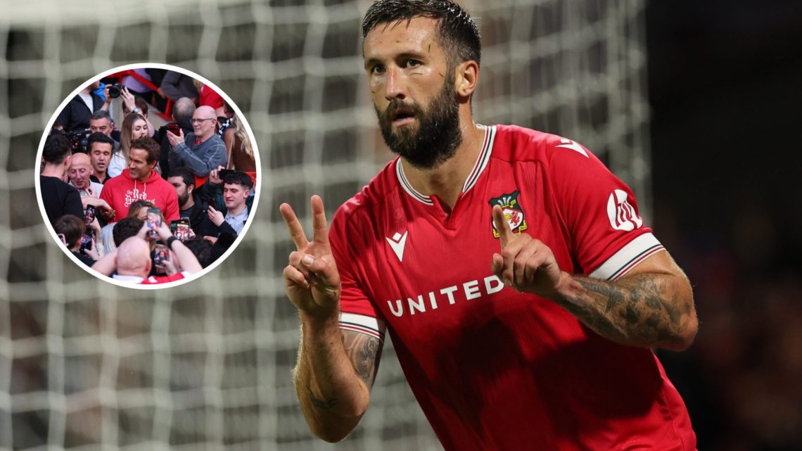 After missing a chance to score, Ollie Palmer of Wrexham signals the 2-1 score. Fans of Wrexham celebrate with Rob McElhenney and Ryan Reynolds.