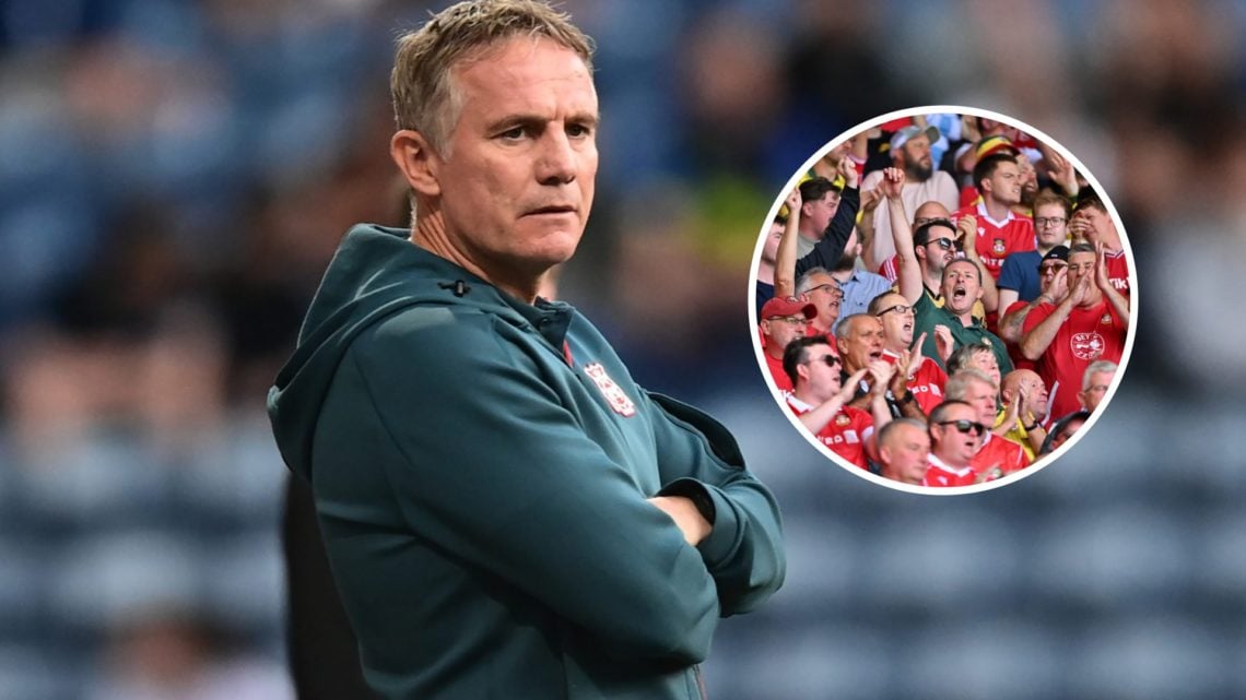 Wrexham manager Phil Parkinson looks on. Fans of Wrexham show their support.