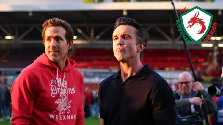 Wrexham co-owners Ryan Reynolds and Rob Mac stand on the pitch.