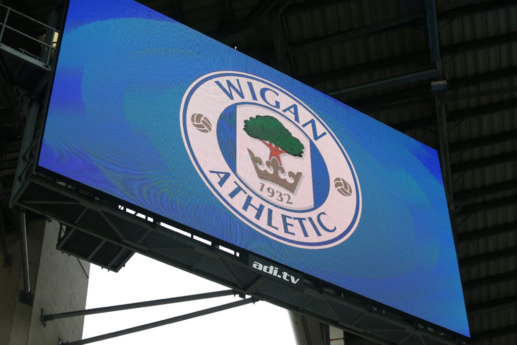 The club crest of Wigan Athletic is seen on a big screen inside DW Stadium