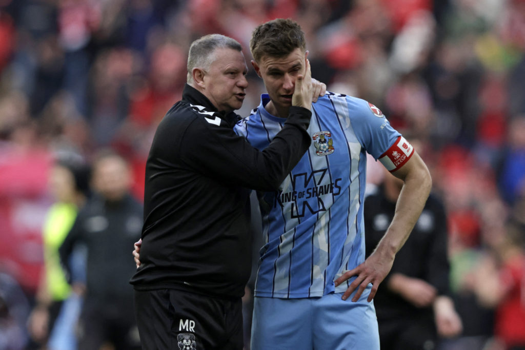 Coventry City's English manager Mark Robins (L) consoles Coventry City's English midfielder #14 Ben Sheaf (R)